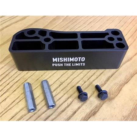 Black aluminum gas pedal spacer with a textured surface, featuring the "Mishimoto Push the Limits" logo, accompanied by two silver bolts and two cylindrical spacers.