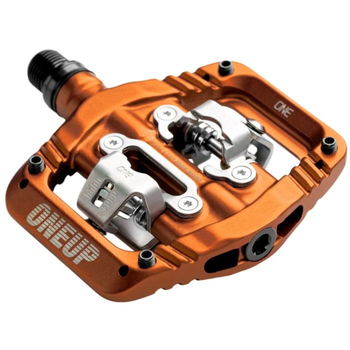 Orange aluminum clip pedal featuring a robust design, adjustable tension, and a sleek finish with the "ONEUP" logo prominently displayed.