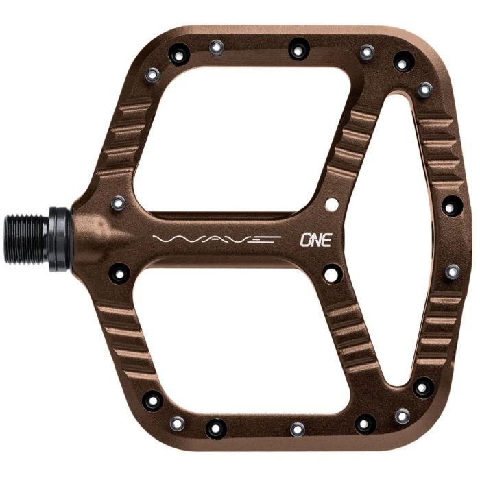 Bronze aluminum OneUp Components Wave Pedals featuring a wide platform, textured grip surface, and strategically placed pins for enhanced traction.