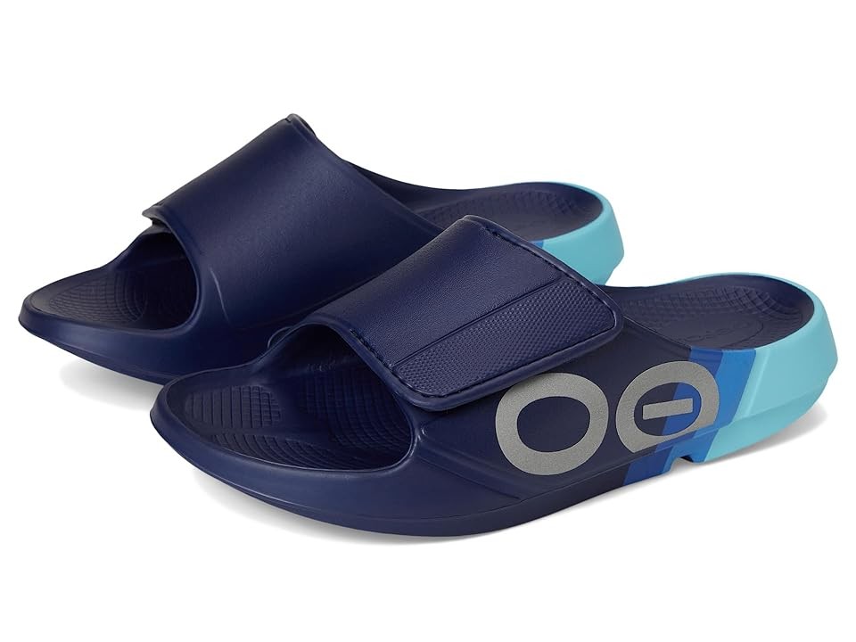 Navy blue recovery slides with a light blue accent, featuring a wide strap and textured footbed for comfort, designed for adults by OOFOS in a limited edition style.