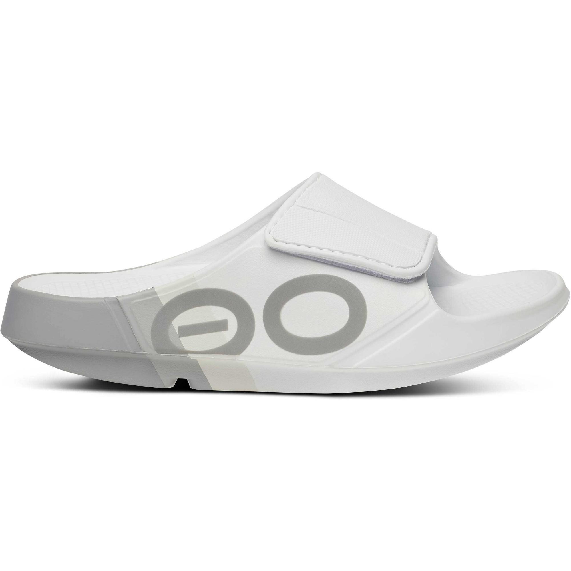 White slide sandal featuring a velcro strap, a sleek design, and a grey logo detail, made from lightweight, cushioned material for comfort.