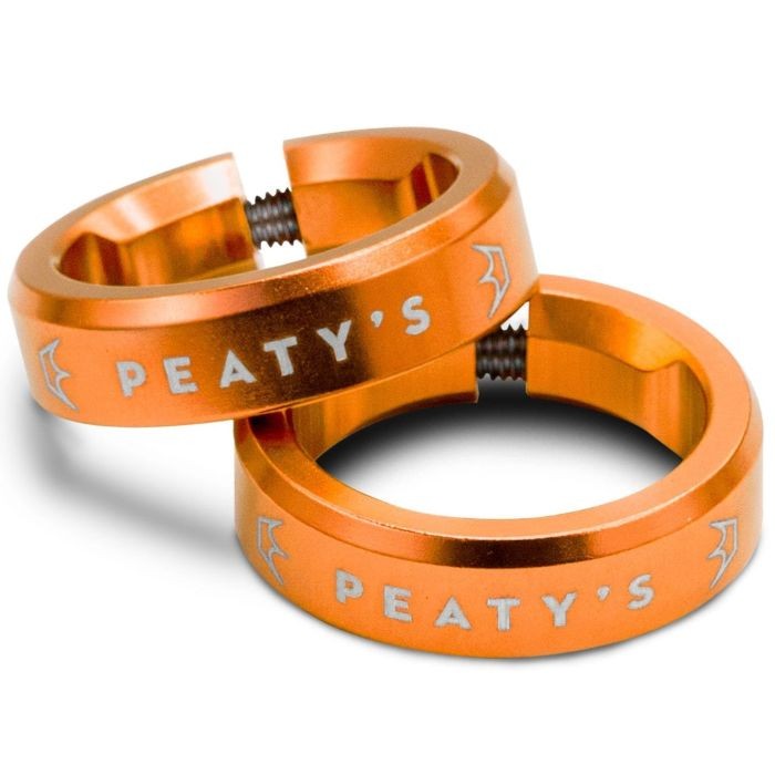 Bright mango-colored aluminum grip lock rings featuring "Peaty's" branding, designed for secure attachment, with a smooth finish and a threaded interior for easy installation.
