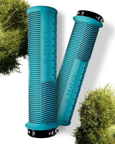 Thick, turquoise rubber grips with textured ridges and Peaty's branding, featuring black end caps, surrounded by green moss.
