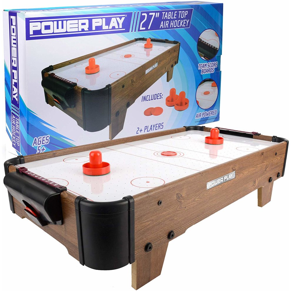 Dark brown air hockey table with a smooth white playing surface, red pucks, and scoreboards, featuring a sturdy wooden frame and compact design for tabletop play.
