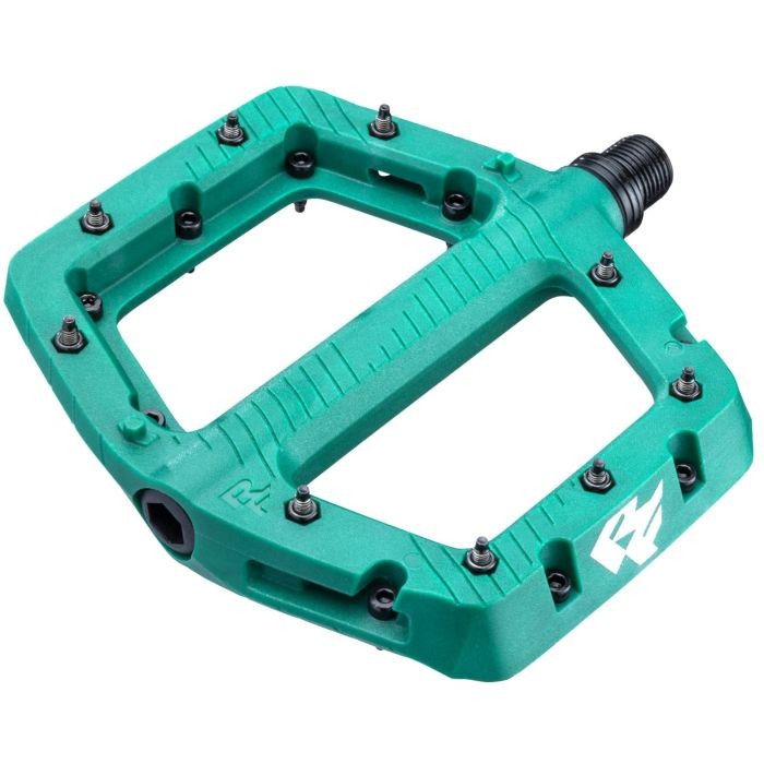 Large Race Face Chester pedals in vibrant teal, featuring a durable plastic body, textured surface for grip, and multiple pins for enhanced traction.