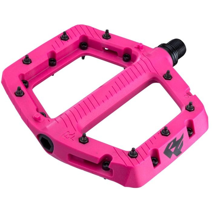 Small magenta Race Face Chester pedals featuring a durable plastic body, textured surface for grip, and multiple pins for enhanced traction.