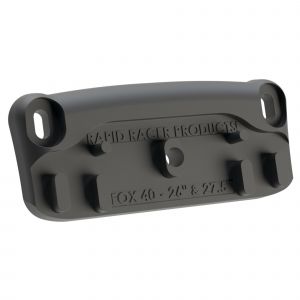 Black plastic bike accessory mount with two holes for attachment, designed for FOX 40 forks, featuring a smooth surface and a compact, sturdy design.