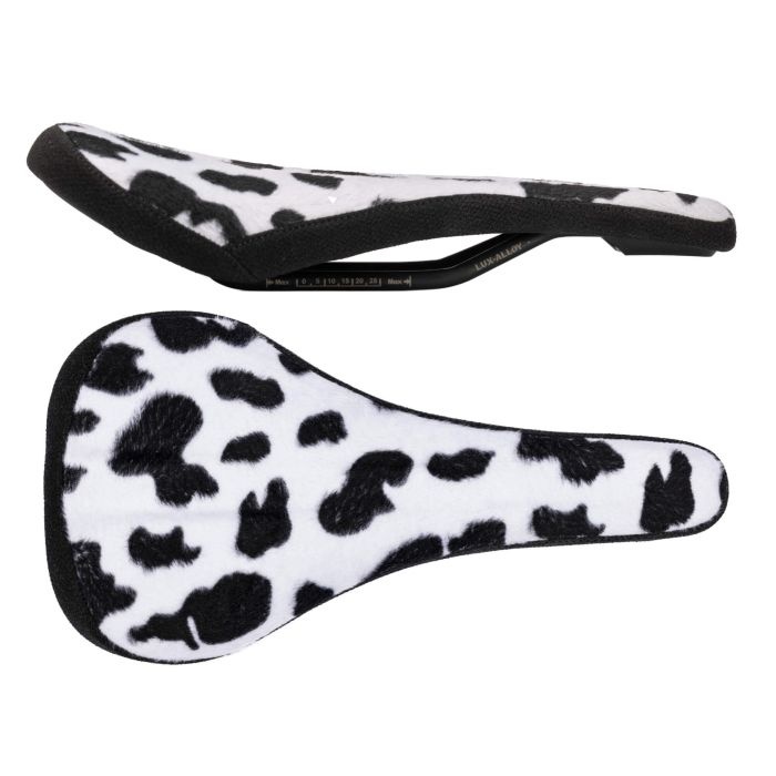 Limited edition SDG Bel-Air V3 saddle in a cow print design, featuring a soft, furry surface, unisex shape, and lightweight construction at 290g, measuring 260 x 140mm.