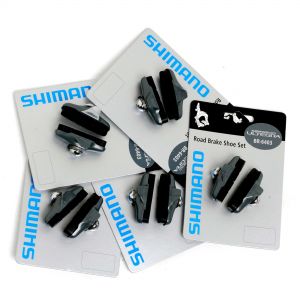 Black Shimano BR 6403 caliper brake shoes with a rubber grip, featuring a silver metal mounting bolt, arranged on packaging cards.
