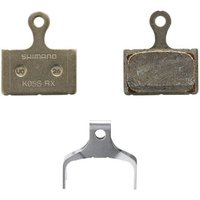Shimano K05S-RX steel back resin disc pads with spring, featuring a metallic finish and compact design.