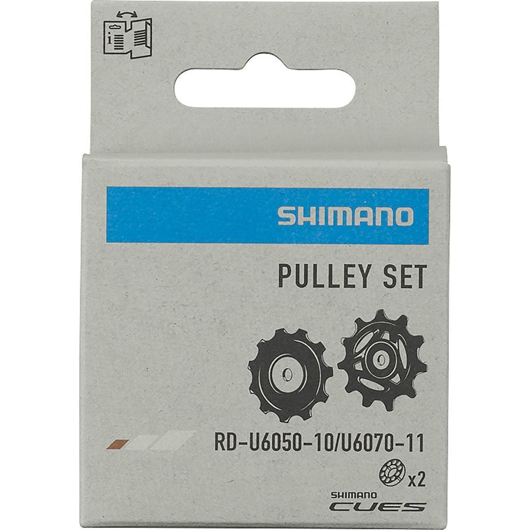 Shimano RD-U6050 Tension & Guide Pulley Set packaging featuring two black pulleys with a silver accent, displayed on a light gray cardboard box with blue and black branding.