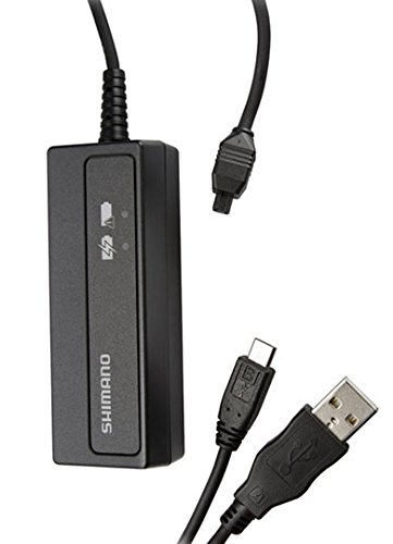 Black Shimano SM-BCR2 Di2 internal battery charger with a USB connector and a micro USB cable, featuring a charging indicator icon on the top.