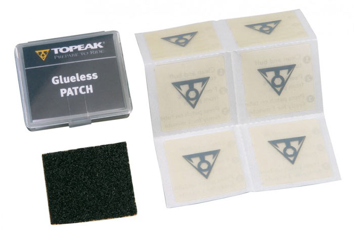 Topeak Glueless Patch Kit includes a clear plastic case with six adhesive patches and a black scuffer for tire repair, featuring the TOPEAK logo on the patches.
