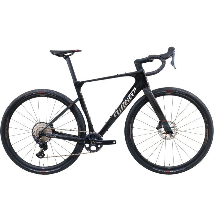 The Wilier Rave SLR ID2 GRX Gravel Bike features a sleek black carbon frame, disc brakes, and a modern design, showcasing its lightweight construction and gravel-ready components.