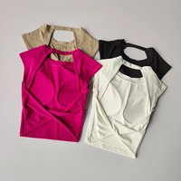 Four women’s sports bras with cutout backs in pink, beige, black, and white, featuring a sleek, breathable design.