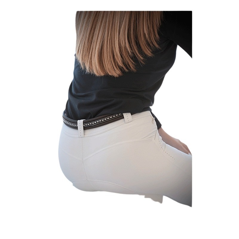 Women's Pénélope Point Sellier belt in black leather, featuring a sleek design with white stitching, worn over white pants, highlighting a stylish and elegant look.