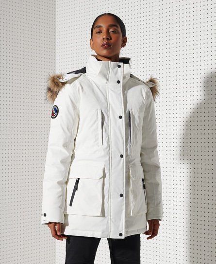Superdry Everest Down Snow Parka Coat in optic white, featuring a fur-trimmed hood, multiple pockets, and a sleek, insulated design for warmth and style.