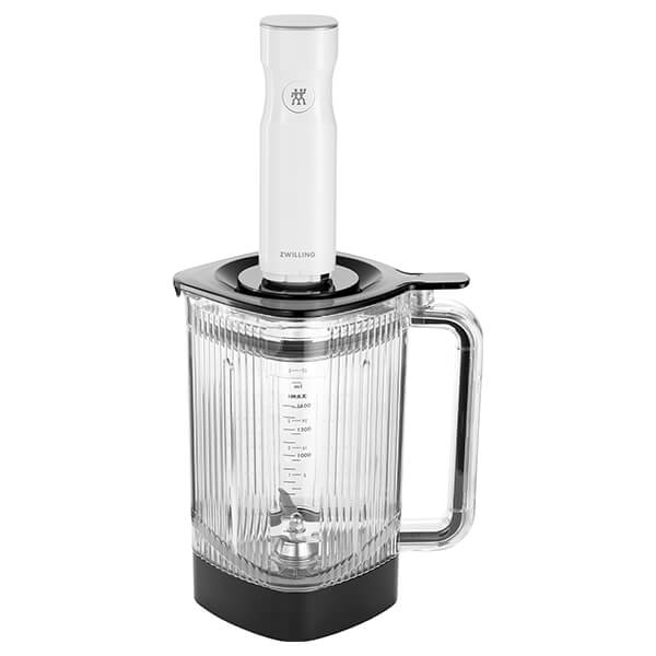 Clear Tritan jar with a black base, featuring measurement markings and a sturdy handle, topped with a white immersion blender for versatile blending.