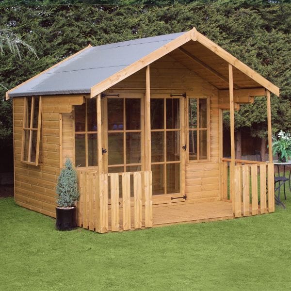 10' x 10' wooden summer house in natural wood finish, featuring a sloped roof, front veranda with railing, and large glass-paneled doors, set against a green lawn and shrubbery.