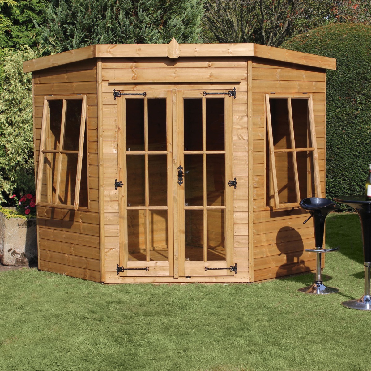 A 6' x 6' traditional wooden summer house in natural wood finish, featuring large glass-paneled doors, multiple windows, and a sloped roof, set on a green lawn.