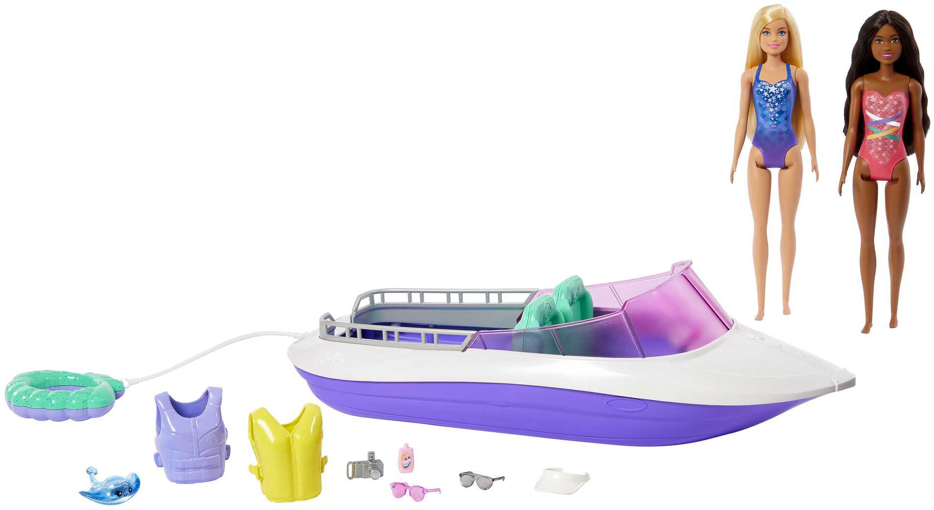 Barbie Mermaid Power Speed Boat Playset features a white and purple boat, two dolls in colorful swimsuits, a life vest, sunglasses, a pink bottle, and a green inner tube.