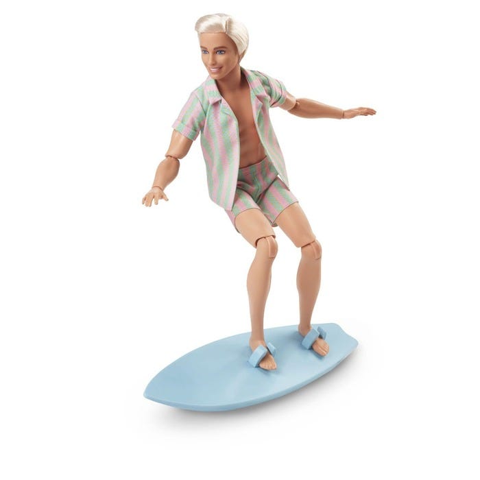 Ken doll features a pastel striped beach outfit with a short-sleeve shirt and matching shorts, standing on a blue surfboard, with light blonde hair styled back.