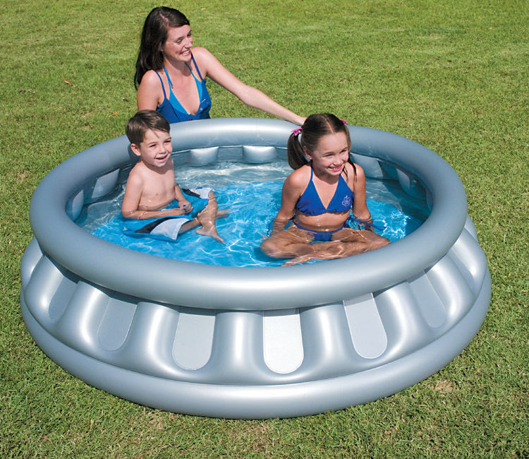 Round, inflatable above-ground swimming pool in silver with a blue interior, featuring two children and an adult enjoying the water on a grassy area.