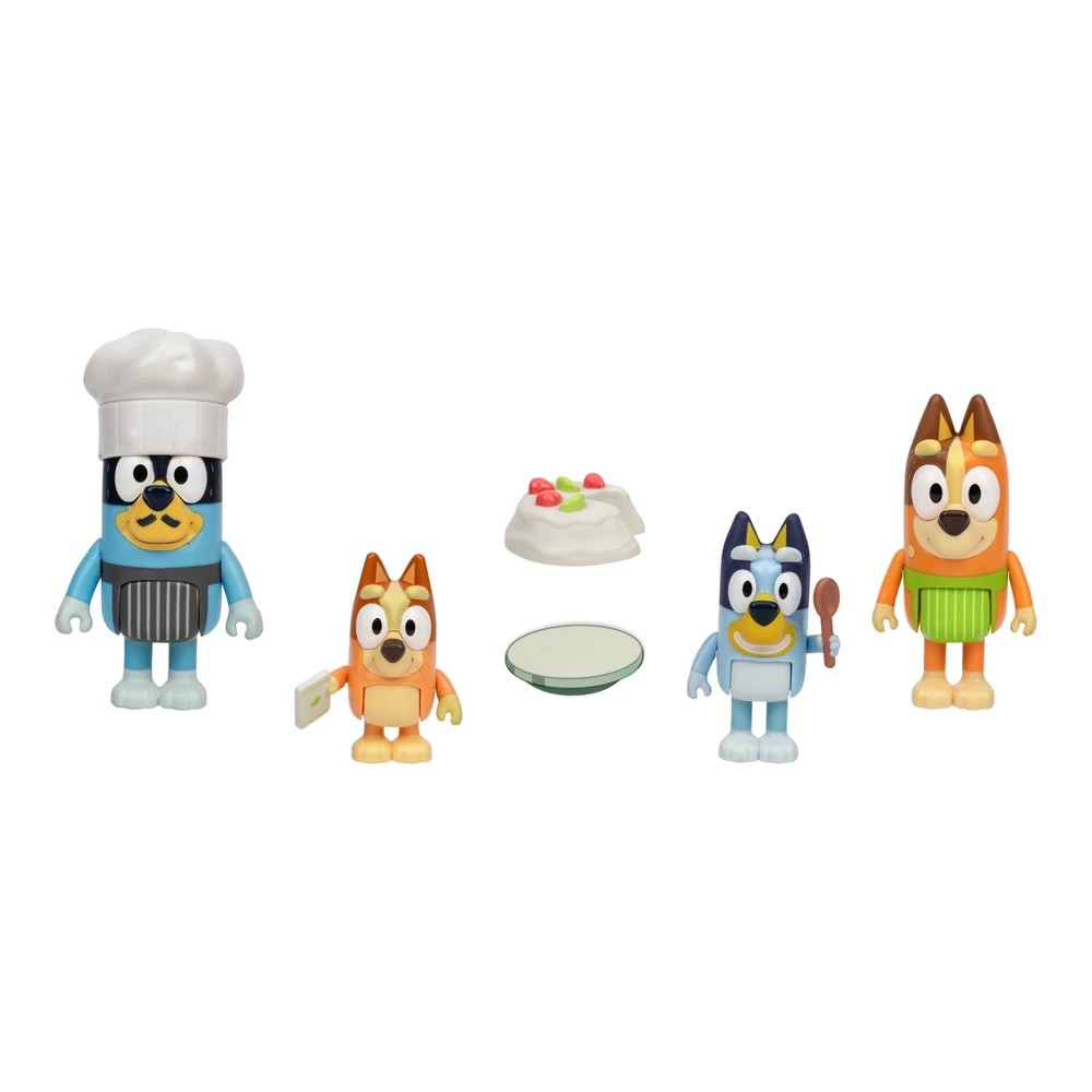 Four colorful plastic figures from Bluey, including Bluey in a chef's hat, Bingo, and two accessories: a pavlova dessert and a plate.