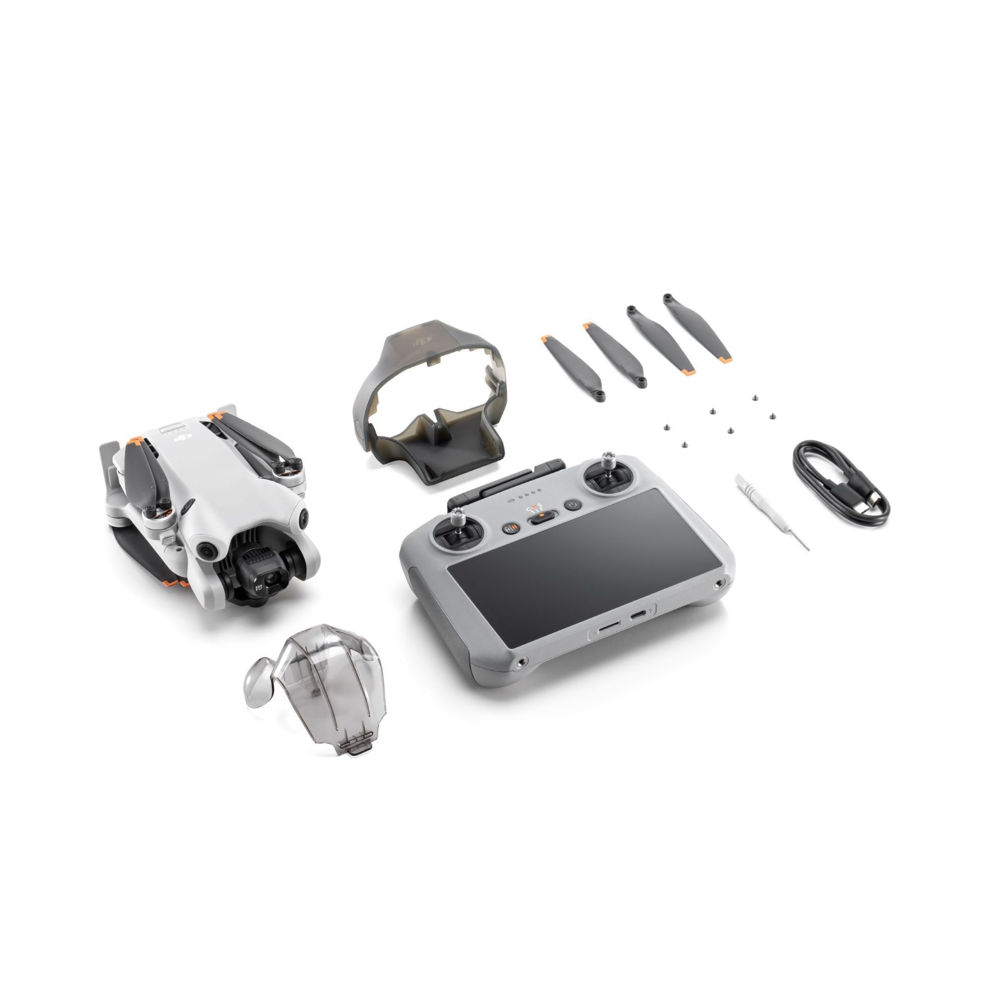 DJI Mini 4 Pro quadcopter in gray with four rotors, 48 MP camera, remote controller with screen, spare propellers, and accessories arranged neatly on a white background.