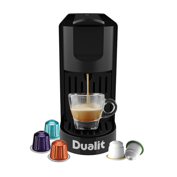 Black Dualit 85190 Coffee Pod Machine with a sleek design, brewing coffee into a clear glass cup, accompanied by colorful coffee pods in various shades.