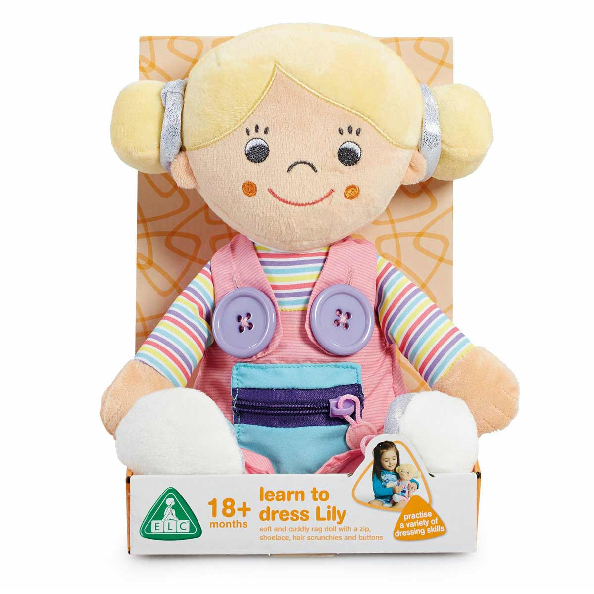Soft rag doll with blonde pigtails, wearing a pink vest with buttons, a striped shirt, and blue overalls, packaged in a colorful box for early dressing practice.