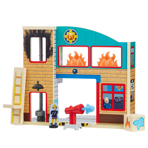 Wooden Fireman Sam fire station playset featuring a brick design, colorful windows, flames, a firefighter figure, a water cannon, and a ladder for imaginative play.