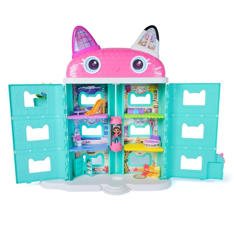 Colorful dollhouse playset featuring a pink cat-shaped roof, turquoise walls, multiple rooms with furniture, and a Gabby figure, designed for imaginative play.