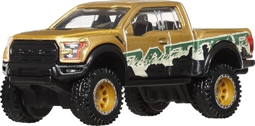Gold and black Hot Wheels Premium 17 Ford F150 Raptor toy truck with oversized wheels, featuring a rugged design and green and white graphics on the side.