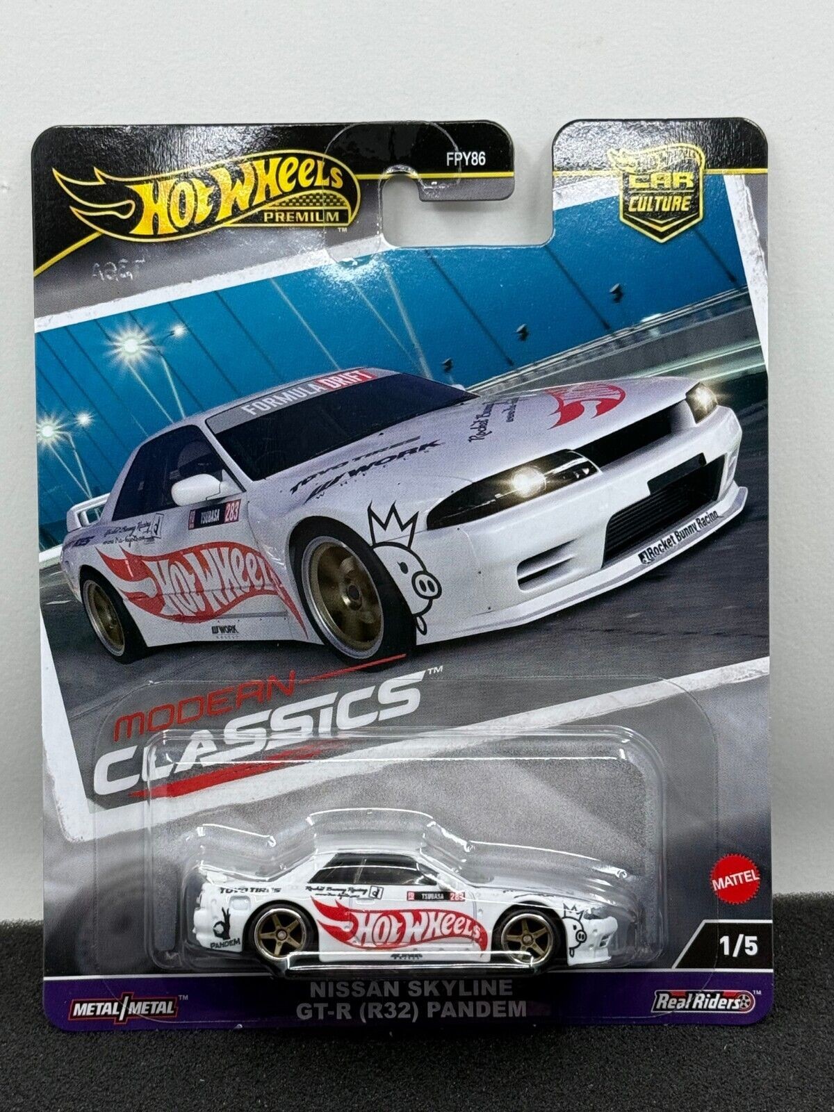 White Nissan Skyline GT-R Pandem model car by Hot Wheels, featuring red and black detailing, a sleek design, and a collectible packaging labeled "Modern Classics."