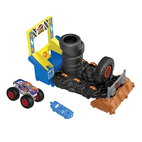 Colorful playset featuring a blue ramp, black tire obstacle, and a red and blue monster truck, designed for racing and smashing challenges. Includes a smaller blue car.