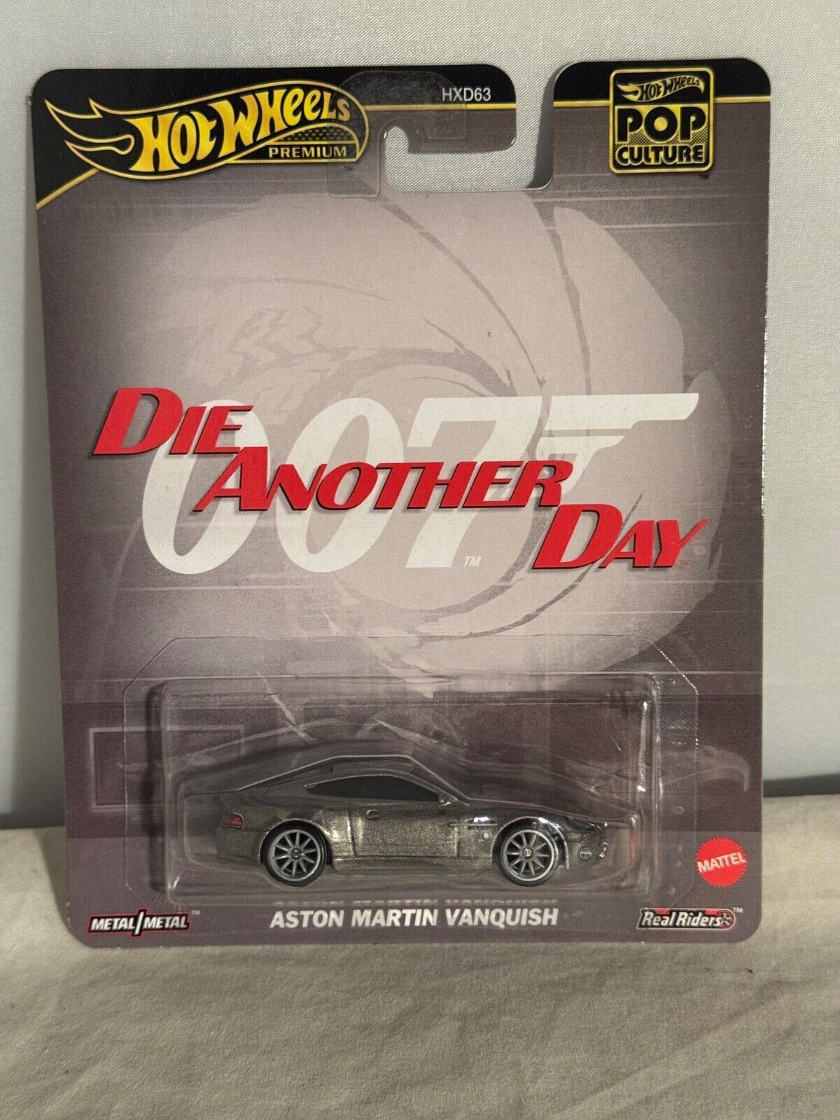 Silver die-cast Aston Martin Vanquish model from "Die Another Day," displayed on a branded Hot Wheels card featuring James Bond graphics and the title "Die Another Day."