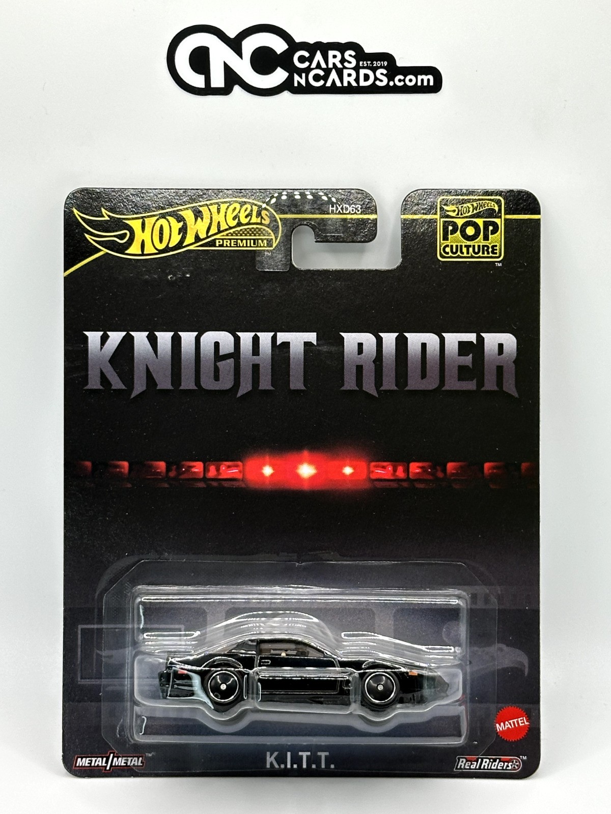 Black die-cast model of K.I.T.T. from Knight Rider, featuring a sleek design, red light bar, and packaged in a collector's card with "Hot Wheels Premium Pop Culture" branding.