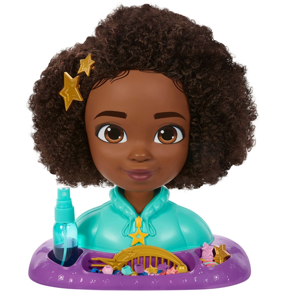 Karma's World styling head features a brown-skinned girl with curly hair, wearing a teal top, accompanied by a spray bottle and colorful hair accessories like stars and clips.