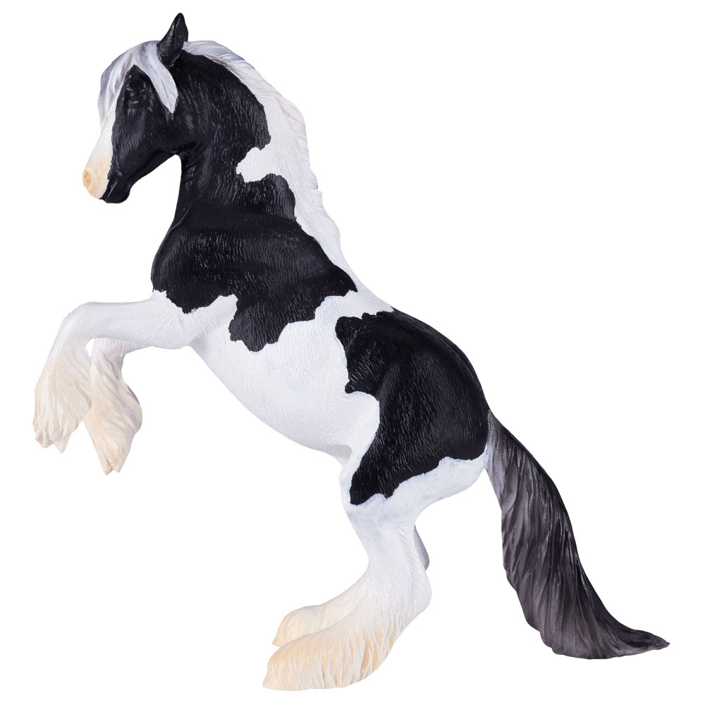 Black and white plastic toy figure of a Gypsy Vanner stallion rearing on its hind legs, featuring detailed mane and tail with fluffy feathering on the legs.
