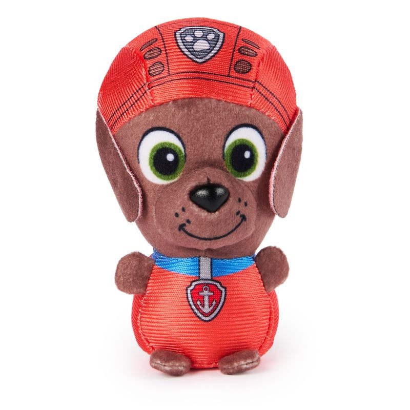 A 9cm soft toy of a brown puppy wearing a red cap with a shield emblem, featuring large green eyes and a smiling expression, made from plush material.