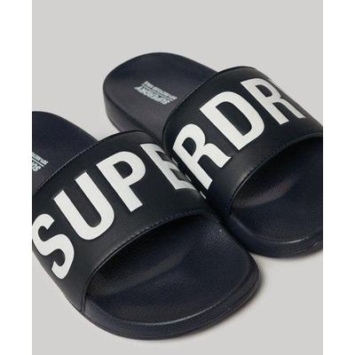 Navy blue vegan pool sliders featuring a wide strap with bold white "SUPERDRY" lettering, designed for comfort, in size 6-7.
