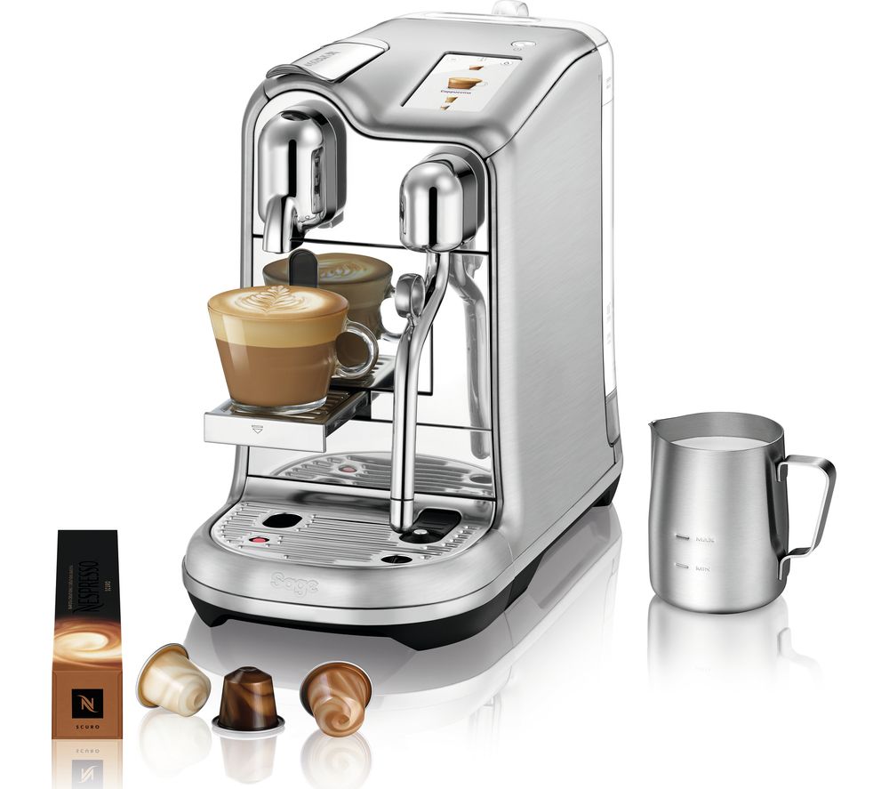 Sleek stainless steel espresso machine with a milk frother, featuring a cup of latte on the drip tray, accompanied by a milk jug and Nespresso capsules.