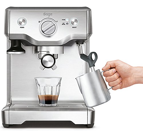Sage Duo-Temp Pro SES810 espresso machine in stainless steel features a steam wand, control knobs, and a glass cup with espresso, while a hand holds a stainless steel milk frother jug.