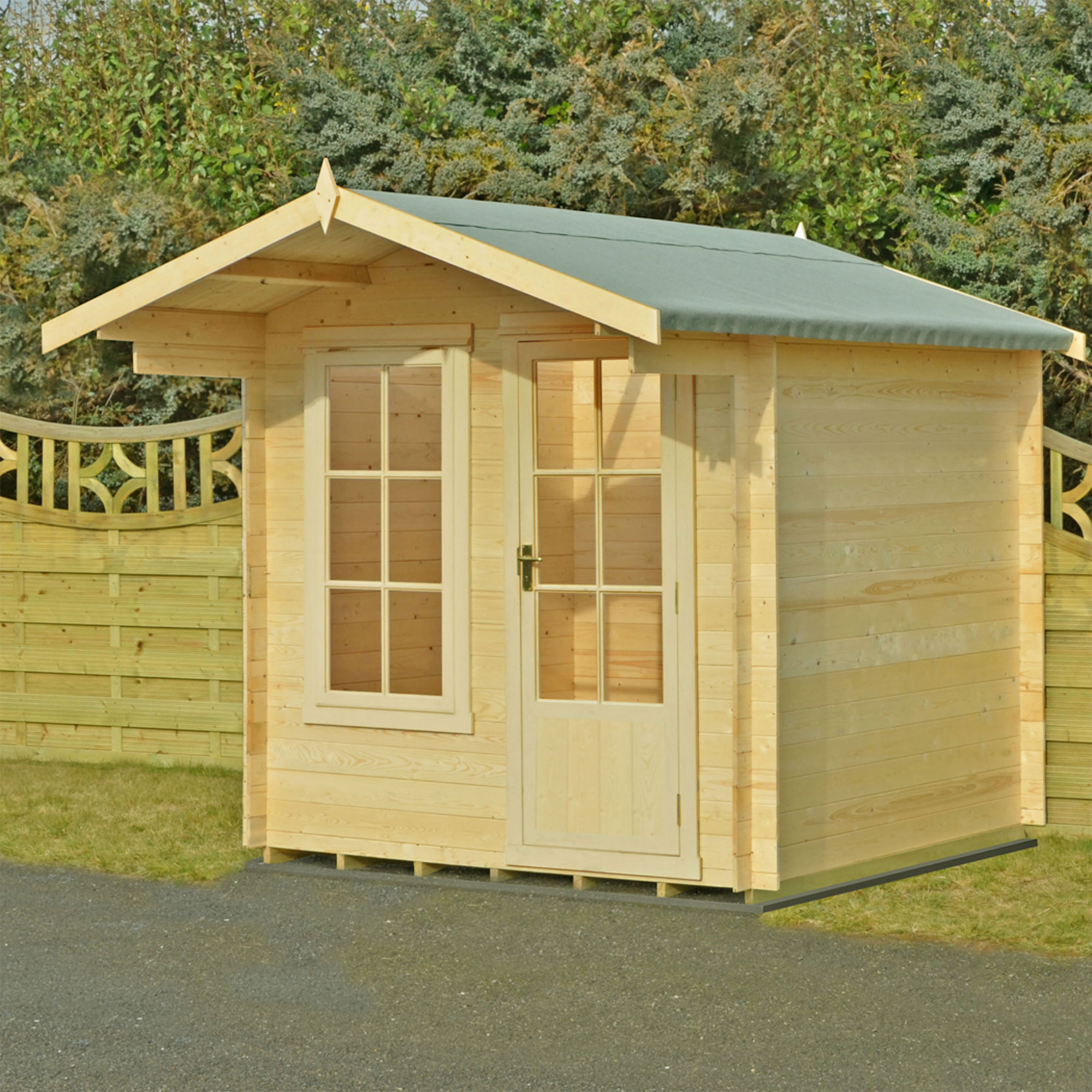 Wooden log cabin summerhouse in natural wood finish, featuring a sloped roof, double front doors with glass panels, and large windows, set against a green backdrop.