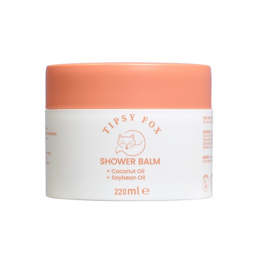 White container with a peach lid, labeled "Tipsy Fox Shower Balm" featuring coconut and soybean oil, 220ml size, with a cute fox graphic on the front.