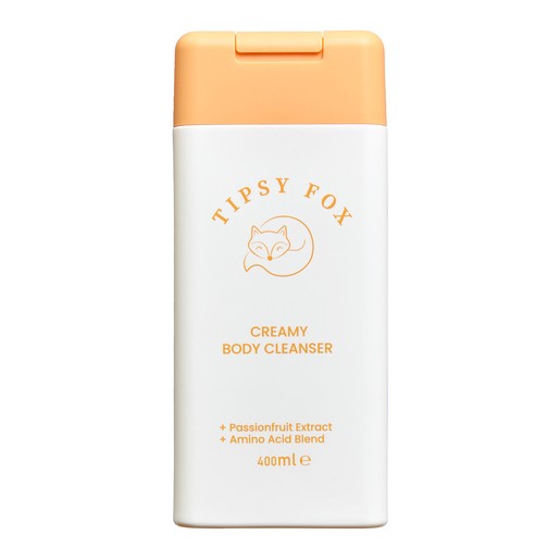 White bottle with a peach-colored cap, featuring "TIPSY FOX" in orange text, labeled as "CREAMY BODY CLEANSER" with passionfruit extract and amino acid blend, 400ml.