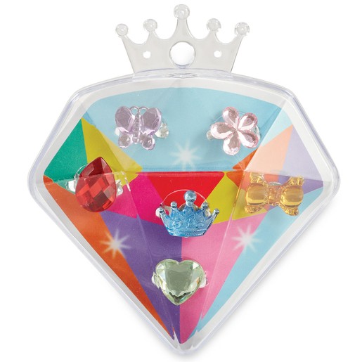Six sparkly gem rings in various shapes, including a crown, heart, flower, and bow, displayed in a colorful diamond-shaped case with a clear lid.