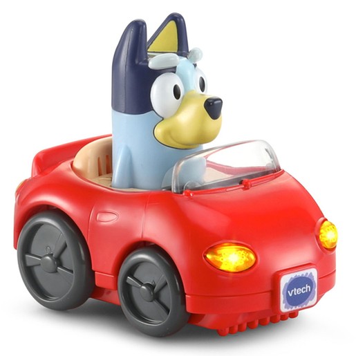 Red convertible toy car with a blue and yellow dog figure in the driver's seat, featuring light-up headlights and a "vtech" logo on the front.