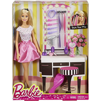 Barbie doll in polka dot top and pink skirt with hair accessories, vanity set, and styling tools in packaging.